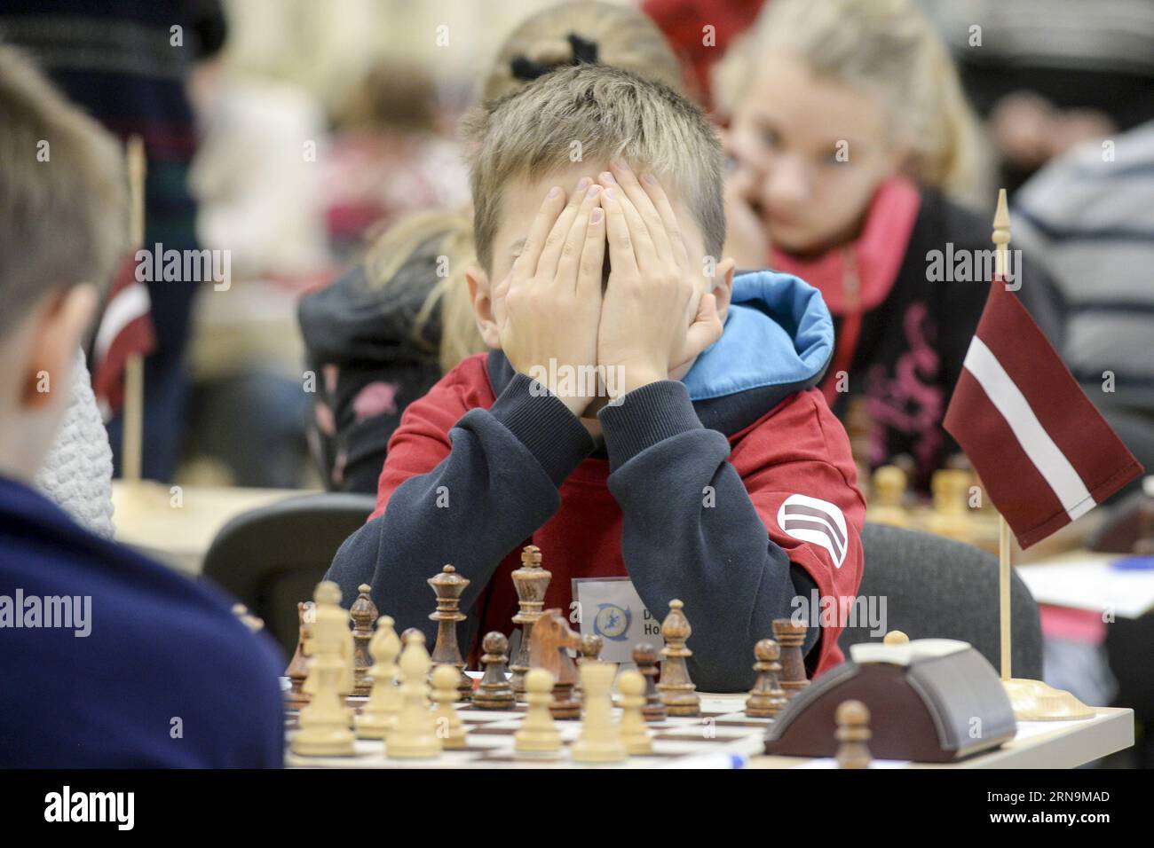 (151211) -- NARVA, Dec. 11, 2015 -- A young chess player covers his face during The Starts of the Baltic Sea chess tournament in Narva, third largest city of Estonia, on Dec. 11, 2015. Sixty young chess players aged 10 to 18 years old from Russia, Estonia, Finland, Latvia and Lithuania competed for the best World Chess Federation (FIDE) rating at this game. The game starts the FIDE celebration of 100 years of World famous Estonian Grandmaster Paul Keres (1916-1975) who was among the world s top players from the mid-1930s to the mid-1960s. Paul Keres was originally from Narva. ) (SP)ESTONIA-NAR Stock Photo