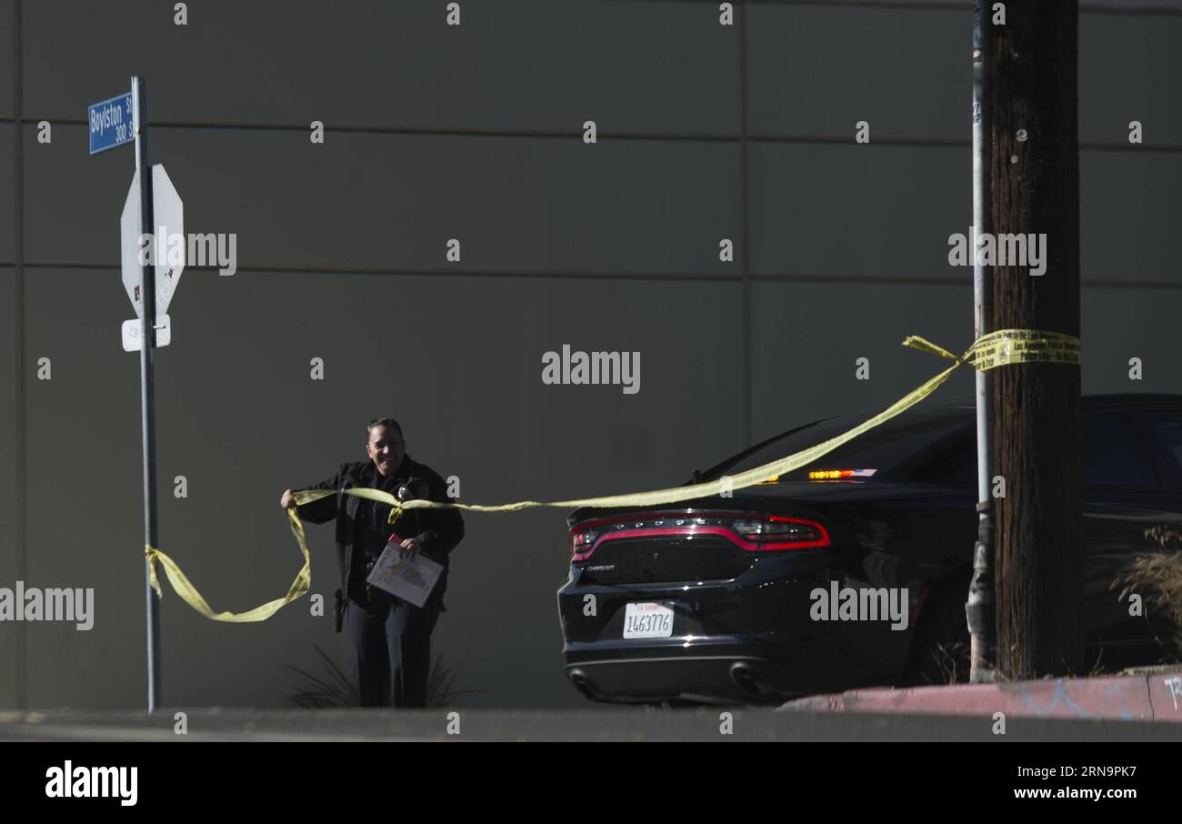 (151215) -- LOS ANGELES, Dec. 15, 2015 -- A police officer puts up yellow tape near the offices of Los Angeles Unified School District (LAUSD), in Los Angeles, the United States, on Dec. 15, 2015. All LAUSD schools will stay closed today in response to a reported bomb threat, Schools Superintendent Ramon Cortines said. Police said the threat was called in to a School Board member. The threat is involving backpacks and packages left at campuses. The closures applied to all LAUSD campuses, around 900 of them. Los Angeles Unified School District is the second-largest school district in United Sta Stock Photo