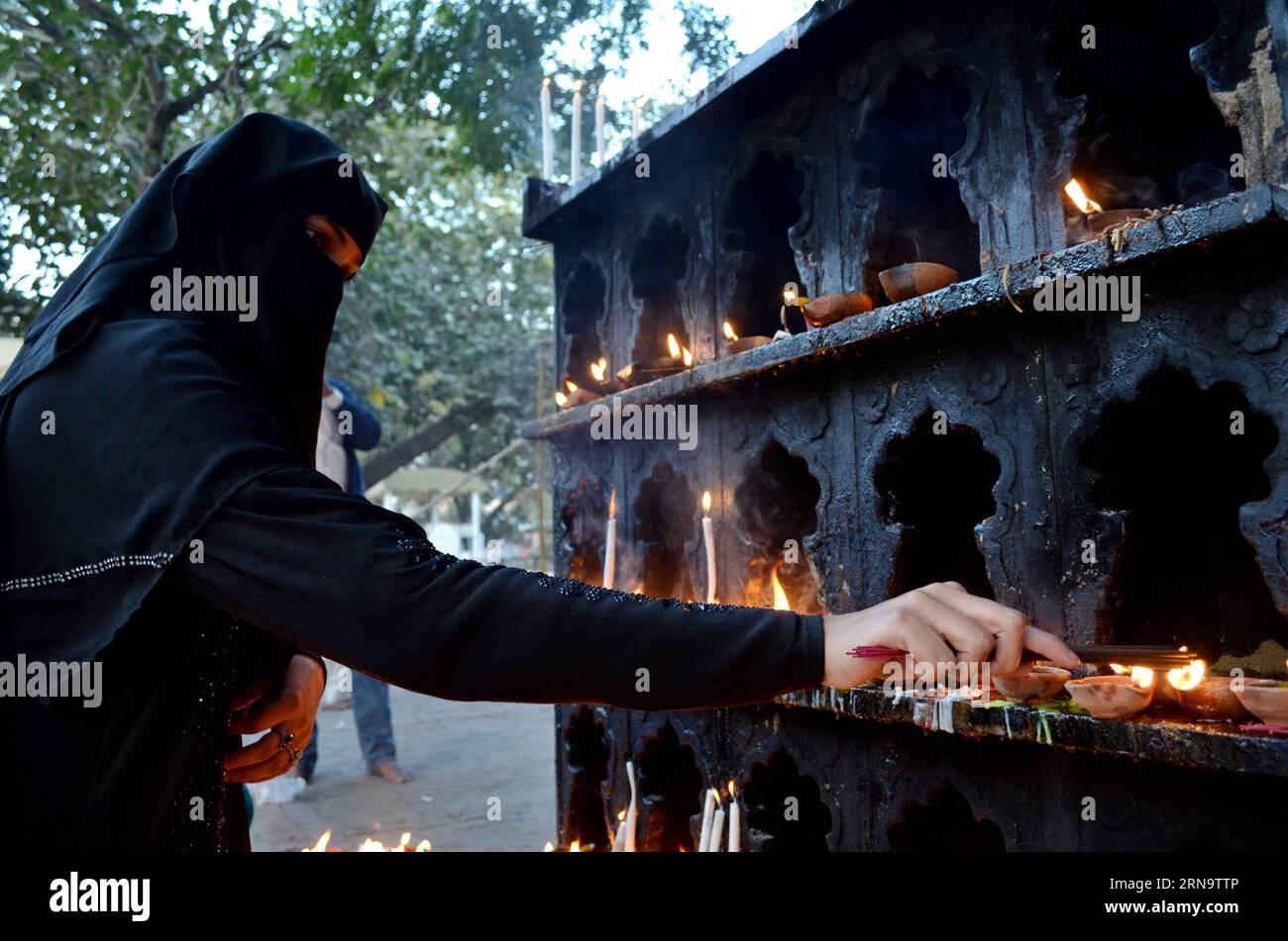 (151220) -- LAHORE, Dec. 19, 2015 -- A Muslim devotee lights candles and oil lamps at the shrine of the Sufi saint Mian Mir Sahib during a festival to mark the saint s death anniversary in eastern Pakistan s Lahore, Dec. 19, 2015. Hundreds of devotees are attending the two-day festival. ) PAKISTAN-LAHORE-RELIGIOUS FESTIVAL JamilxAhmed PUBLICATIONxNOTxINxCHN   151220 Lahore DEC 19 2015 a Muslim devotee Lights Candles and Oil lamps AT The Shrine of The Sufi Saint Mian me Sahib during a Festival to Mark The Saint S Death Anniversary in Eastern Pakistan S Lahore DEC 19 2015 hundreds of devotees ar Stock Photo