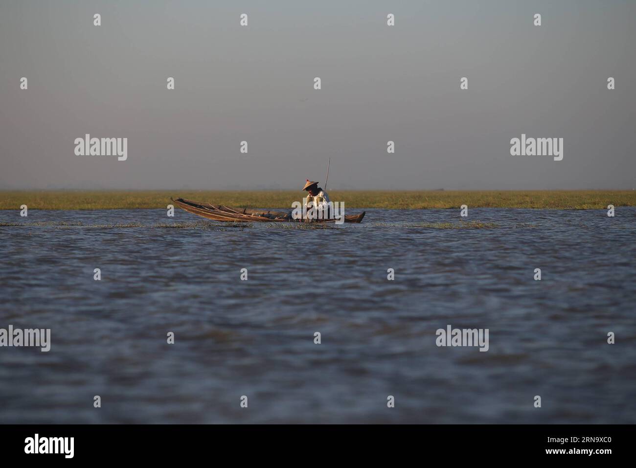 (151223) -- BAGO, Dec. 23, 2015 -- A fisherman works at Moeyungyi Wetland Wildlife Sanctuary in Bago region, Myanmar, Dec. 23, 2015. Moeyungyi Wetlands is situated in Bago Division. Every year, millions of birds usually fly from the northern hemisphere to the south along the East-Asian Australian Flyway to escape from winter. They stop to rest and feed in Asia. So the flyway contains a network of wetlands and Moeyungyi is one of which could cooperate to certain migrated as well as domestic birds. ) MYANMAR-BAGO-WETLAND-WILDLIFE UxAung PUBLICATIONxNOTxINxCHN   151223 Bago DEC 23 2015 a Fisherma Stock Photo