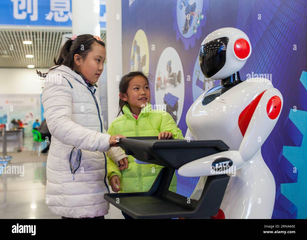 (160108) -- HOHHOT, Jan. 8, 2016 -- Two girls interact with a robot during a robot carnival in Hohhot, capital of north China s Inner Mongolia Autonomous Region, Jan. 8, 2016. A carnival was held here to invite younsters to come and engage high technology of modern robot. ) (cxy) CHINA-INNER MONGOLIA-ROBOT-CARNIVAL (CN) DingxGenhou PUBLICATIONxNOTxINxCHN   160108 Hohhot Jan 8 2016 Two Girls interact With a Robot during a Robot Carnival in Hohhot Capital of North China S Inner Mongolia Autonomous Region Jan 8 2016 a Carnival what Hero Here to invite younsters to Come and Engage High Technology Stock Photo