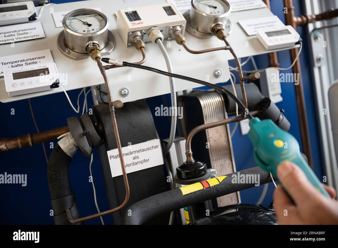 31 August 2023, Brandenburg, Groß Kreutz: A man holds a measuring device for refrigerants in the 'heat pump laboratory' of the Potsdam Chamber of Crafts at the Handwerk Education and Innovation Campus (BIH). Photo: Sebastian Christoph Gollnow/dpa Stock Photo