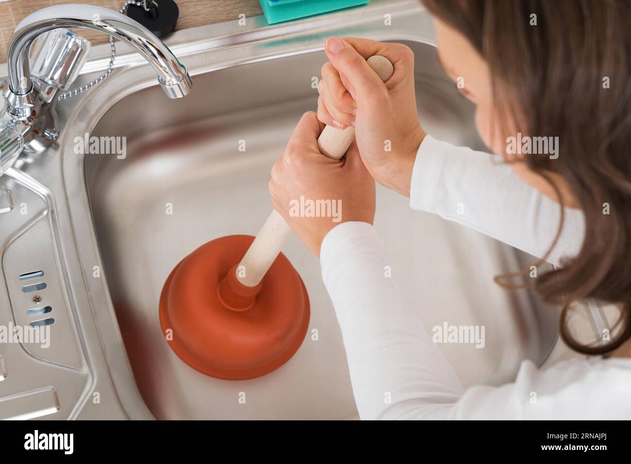 Happy Woman Looking At Male Plumber Using Plunger In The Kitchen Sink,  Stock Photo, Picture And Low Budget Royalty Free Image. Pic. ESY-048550729