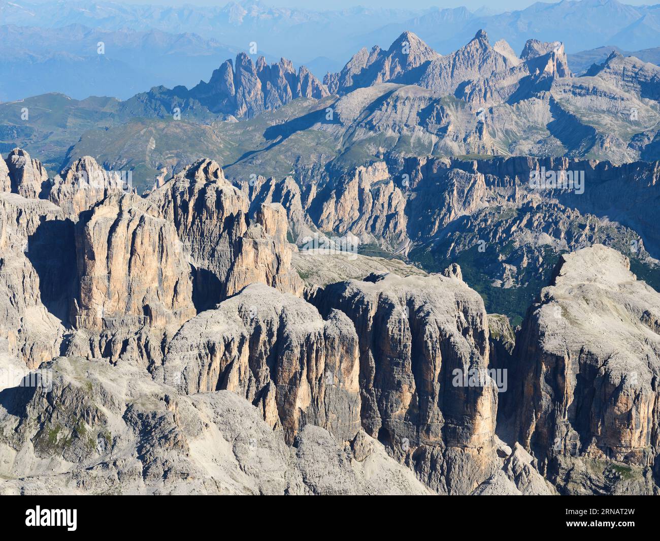 AERIAL VIEW. The incredibly jagged landscape of the Sella Massif with the Puez-Geisler Nature Park in the distance. Dolomites, Italy. Stock Photo