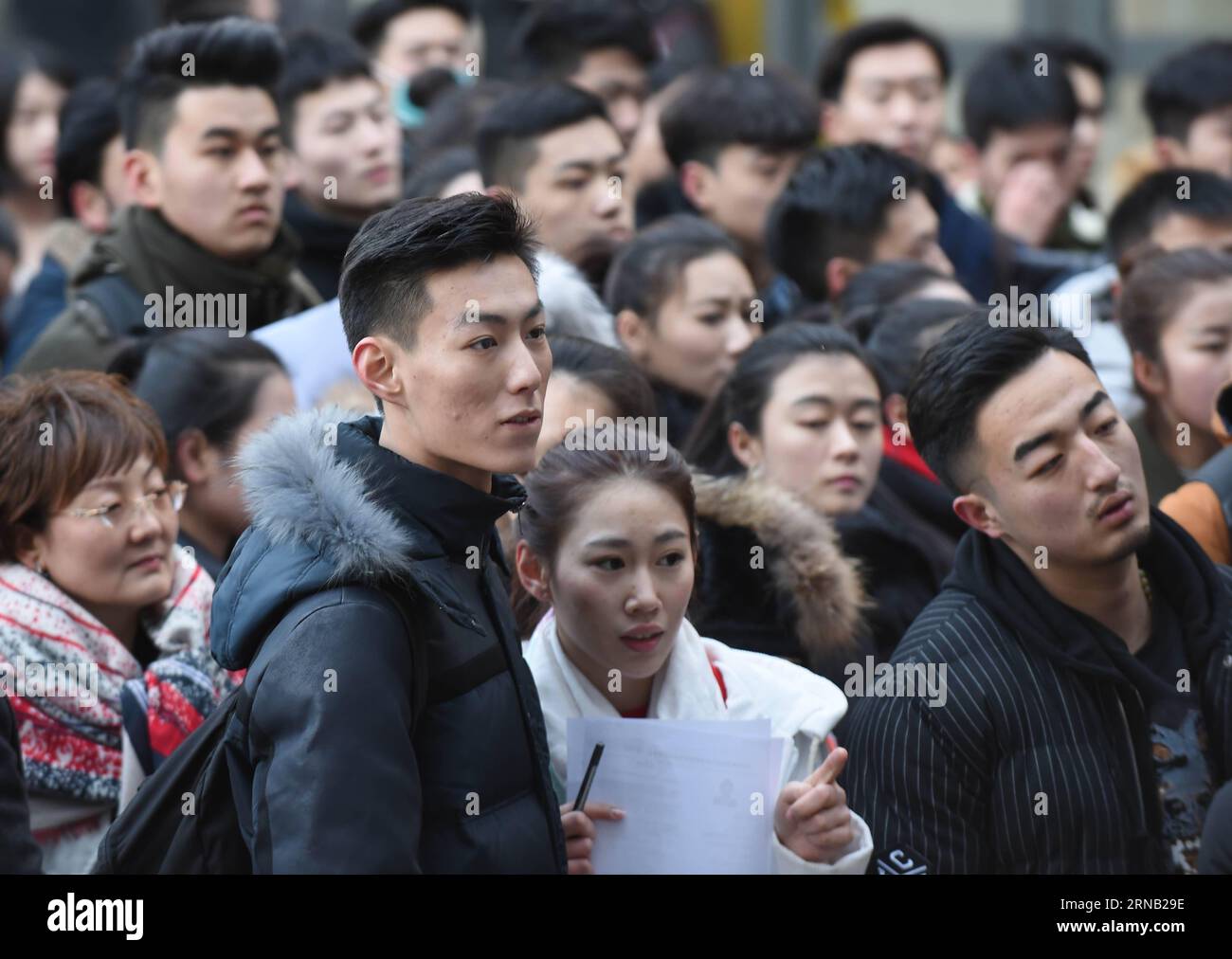 Candidates wait outside the examination hall at Beijing Film Academy (BFA) in Beijing, capital of China, Feb. 15, 2016. The annual entrance exam of China s art colleges including BFA, the Central Academy of Drama and the Communication University of China started simultaneously on Monday. Over 7,600 applicants for BFA s performance institute will take part in the exam to vie for 45 vacancies in the institute. Some Chinese young people regarded studying in an art college as a shortcut to become famous in recent years. )(mcg) CHINA-BEIJING-ART PROFESSIONAL-EXAM (CN) LixWen PUBLICATIONxNOTxINxCHN Stock Photo