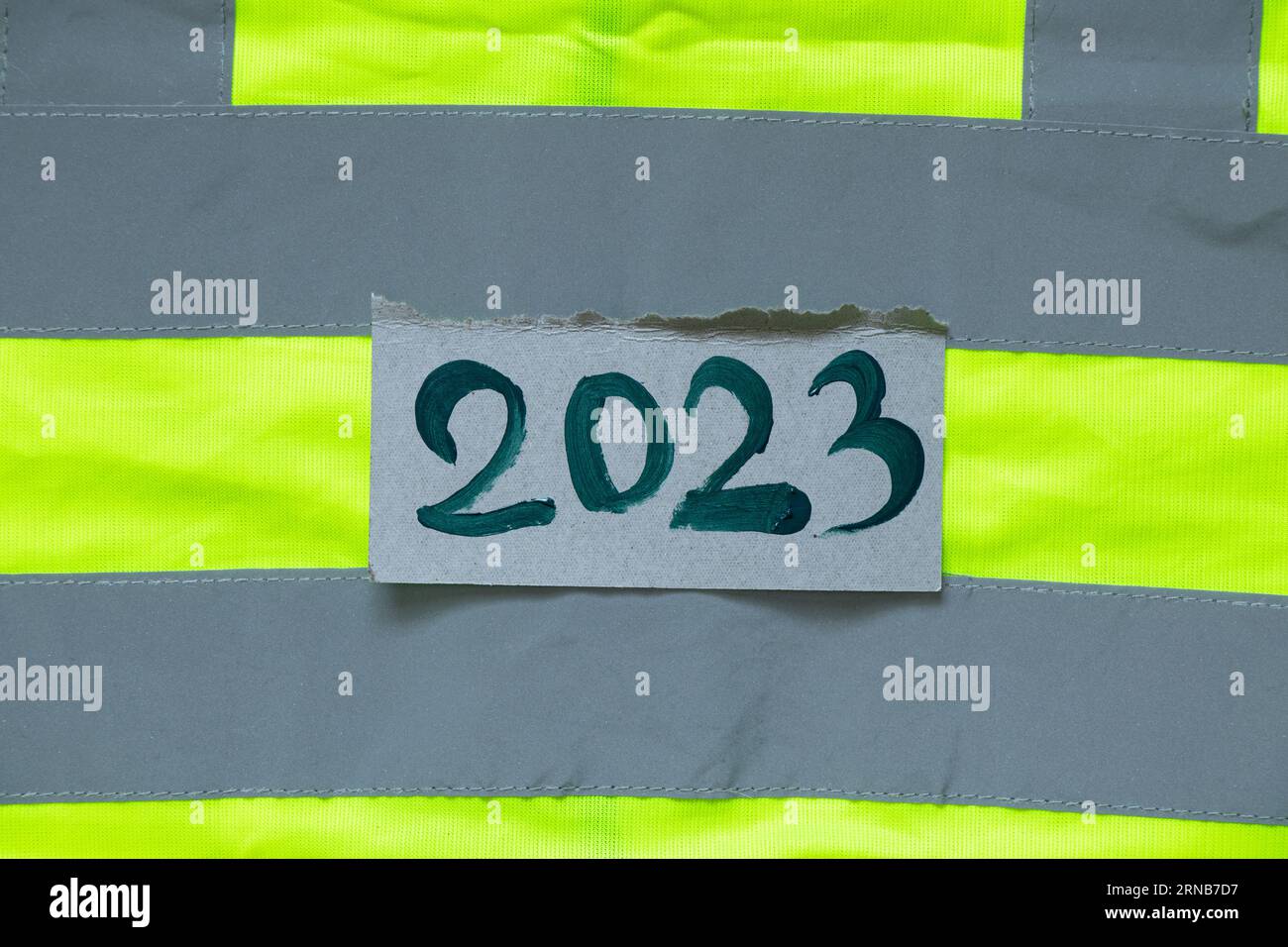 2023 written in green paint lies on a reflective vest, Happy New Year 2023, banner and background, special clothing and work Stock Photo
