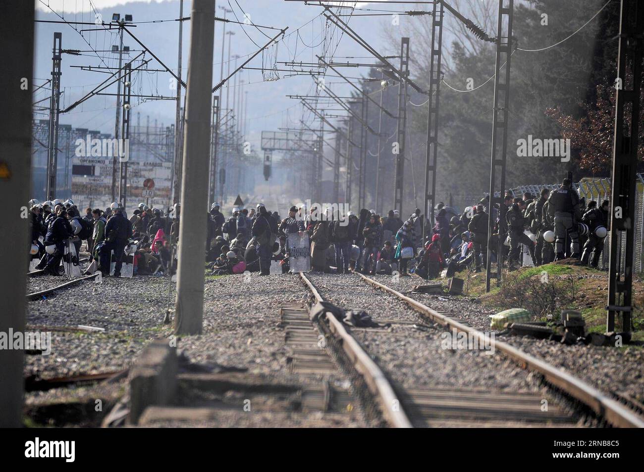 Afghan migrants protest and stand behind the wire fencing at the closed Greek-Macedonian border, near the Macedonian city of Gevgelija on Feb. 23, 2016. Macedonia has confirmed that it only allowed Syrian and Iraqi refugees through, matching a decision by its northern neighbor, Serbia. Around 5,000 migrants were waiting at the border wishing to continue their journey across Macedonia, Serbia, Croatia, Slovenia and then Austria, with Germany the final goal for most. MACEDONIA-GEVGELJA-MIGRANTS Biljana, PUBLICATIONxNOTxINxCHN   Afghan Migrants Protest and stand behind The Wire fencing AT The Clo Stock Photo