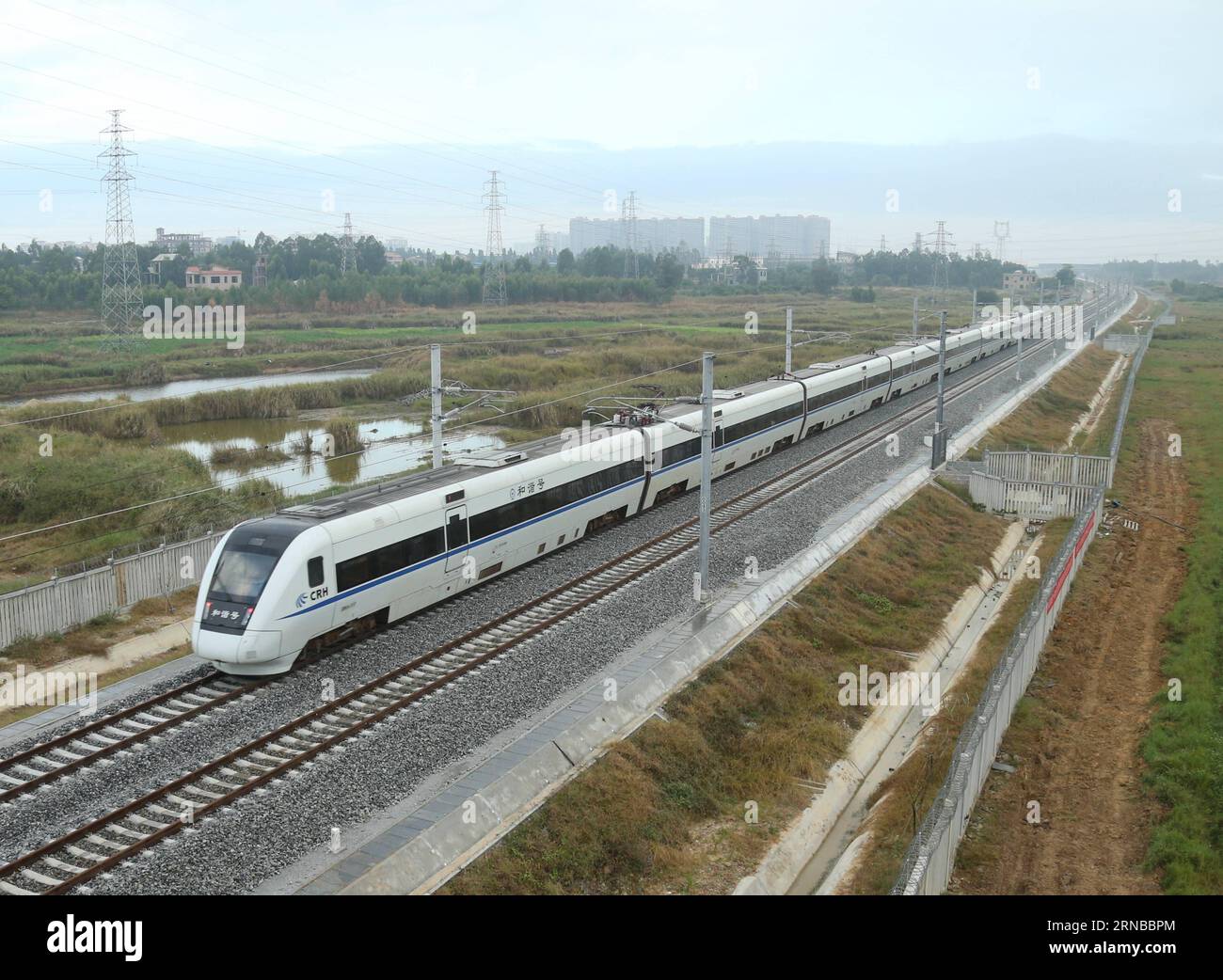 File photo taken on Dec. 29, 2015 shows a bullet train running on the western part of a loop line of Hainan high-speed railway in south China s island of Hainan Province. Building more high-speed railways has been a hot topic at the annual sessions of China s provincial legislatures and political advisory bodies intensively held in January. China has the world s largest high-speed rail network, with the total operating length reaching 19,000 km by the end of 2015, about 60 percent of the world s total. The expanding high-speed rail network is offering unprecedented convenience and comfort to t Stock Photo