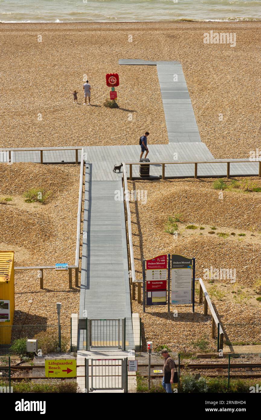 Boardwalk on shingle beach at Brighton in East Sussex, England. With people. Stock Photo