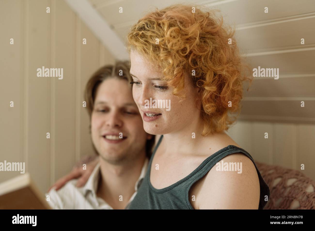 Couple reading book together at home during weekend Stock Photo