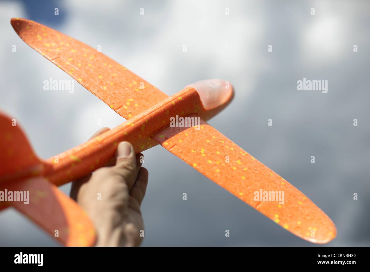 Toy plane in hand. Airplane to play. Lightweight glider. Stock Photo
