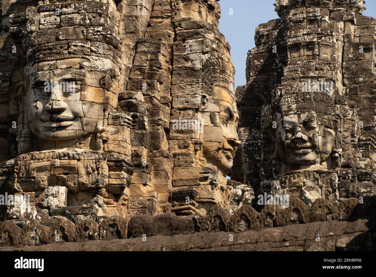 Three giant stone face at the Bayon Temple at Angkor Wat, Cambodia. Stock Photo
