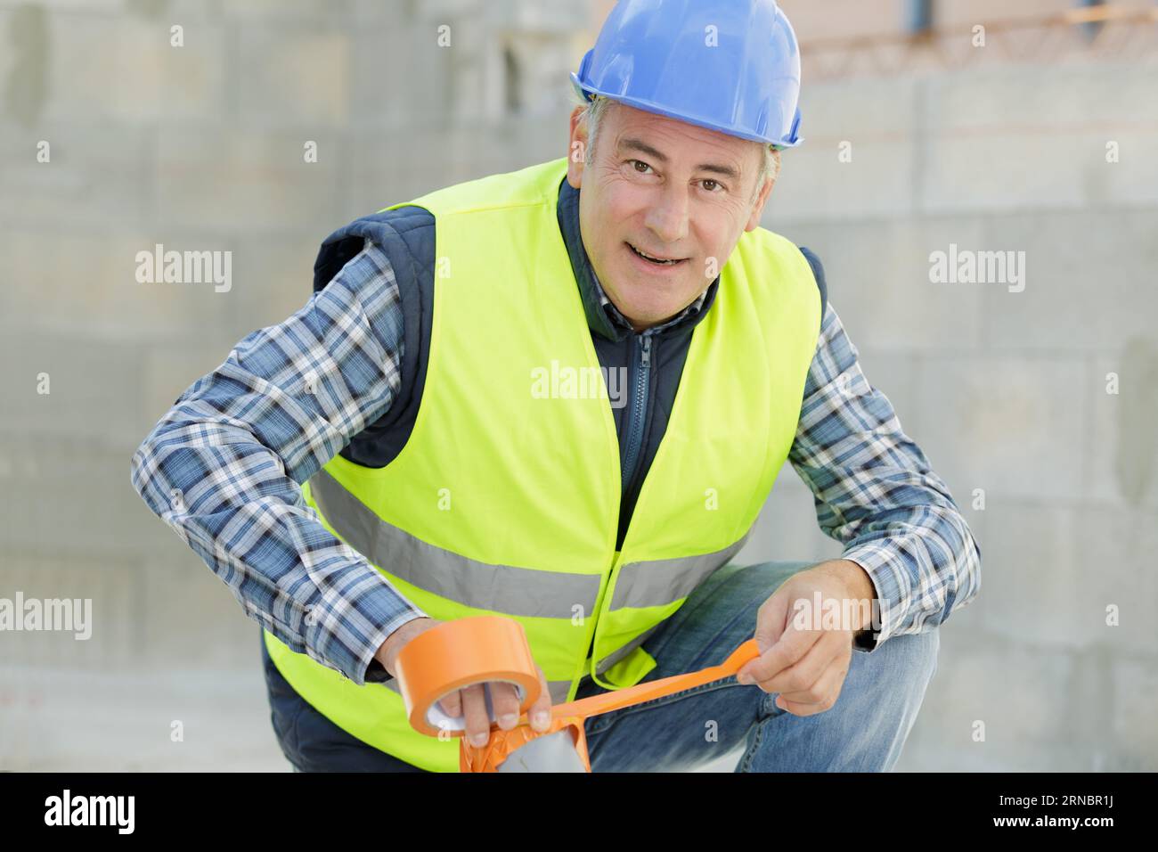 workman using adhesive tape outdoors Stock Photo