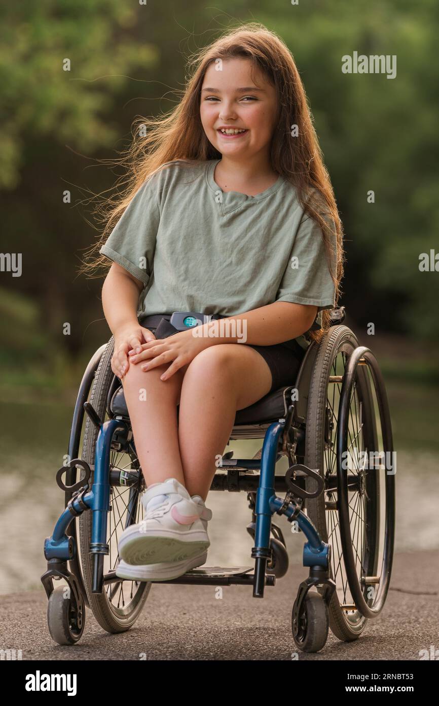 A girl in a wheelchair with her hair blowing in the wind Stock Photo