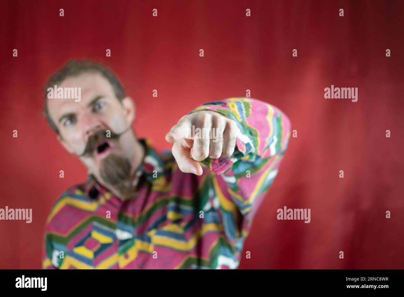 Angry hipster man pointing at camera shouting and with furious expression Stock Photo
