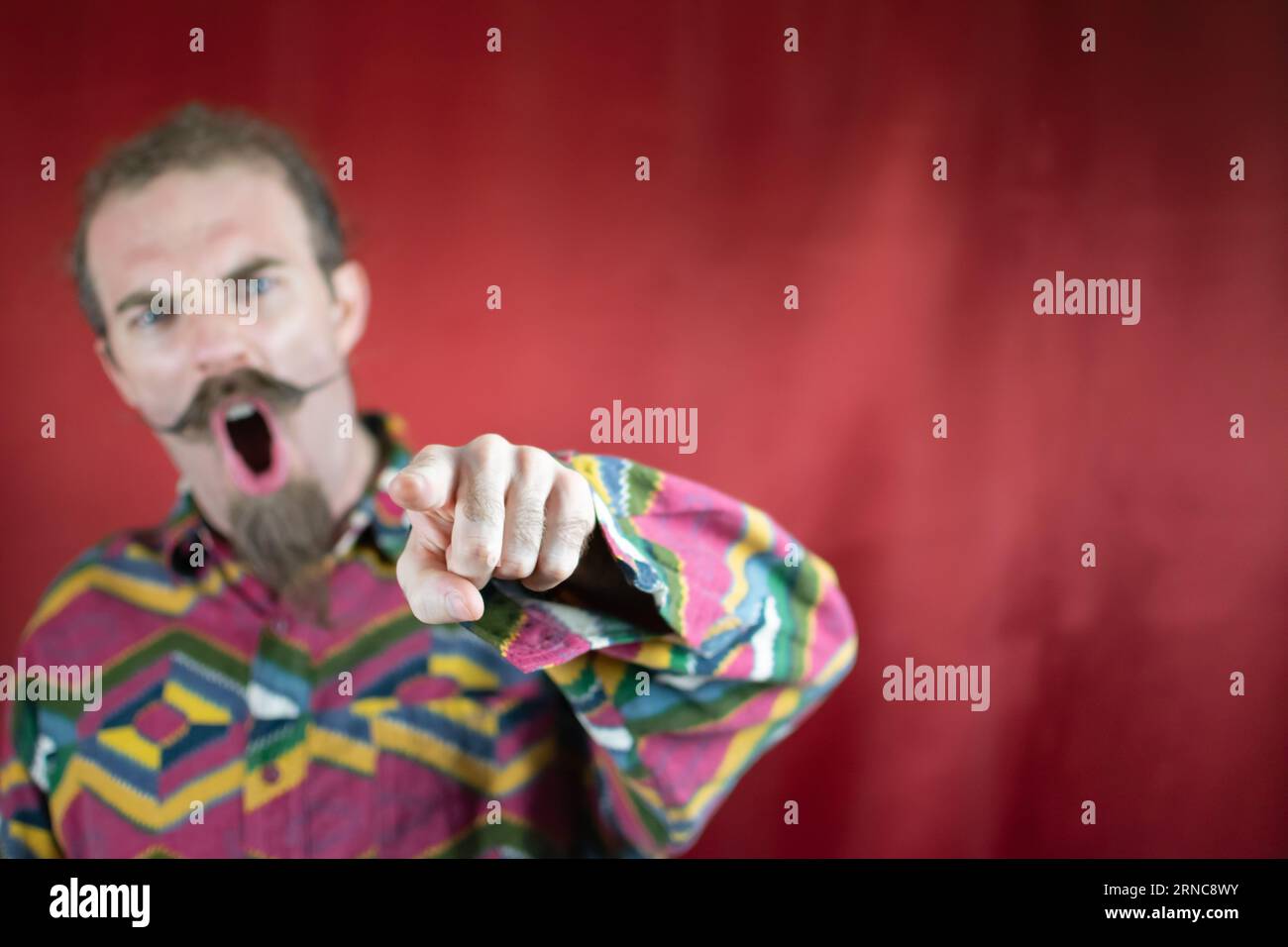Angry hipster man pointing at camera shouting and with furious expression Stock Photo