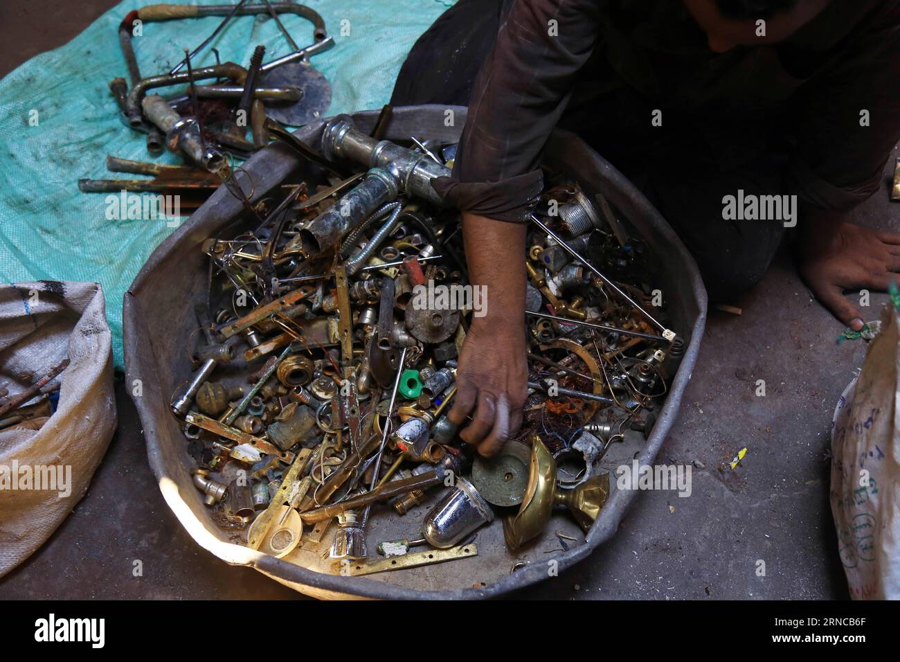 ALEXANDRIA, A worker sorts scrap metal to be recycled and