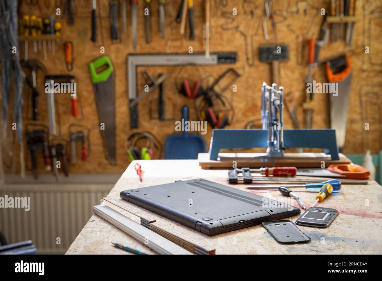 Laptop kept on table with tools at electronic recycling center Stock Photo