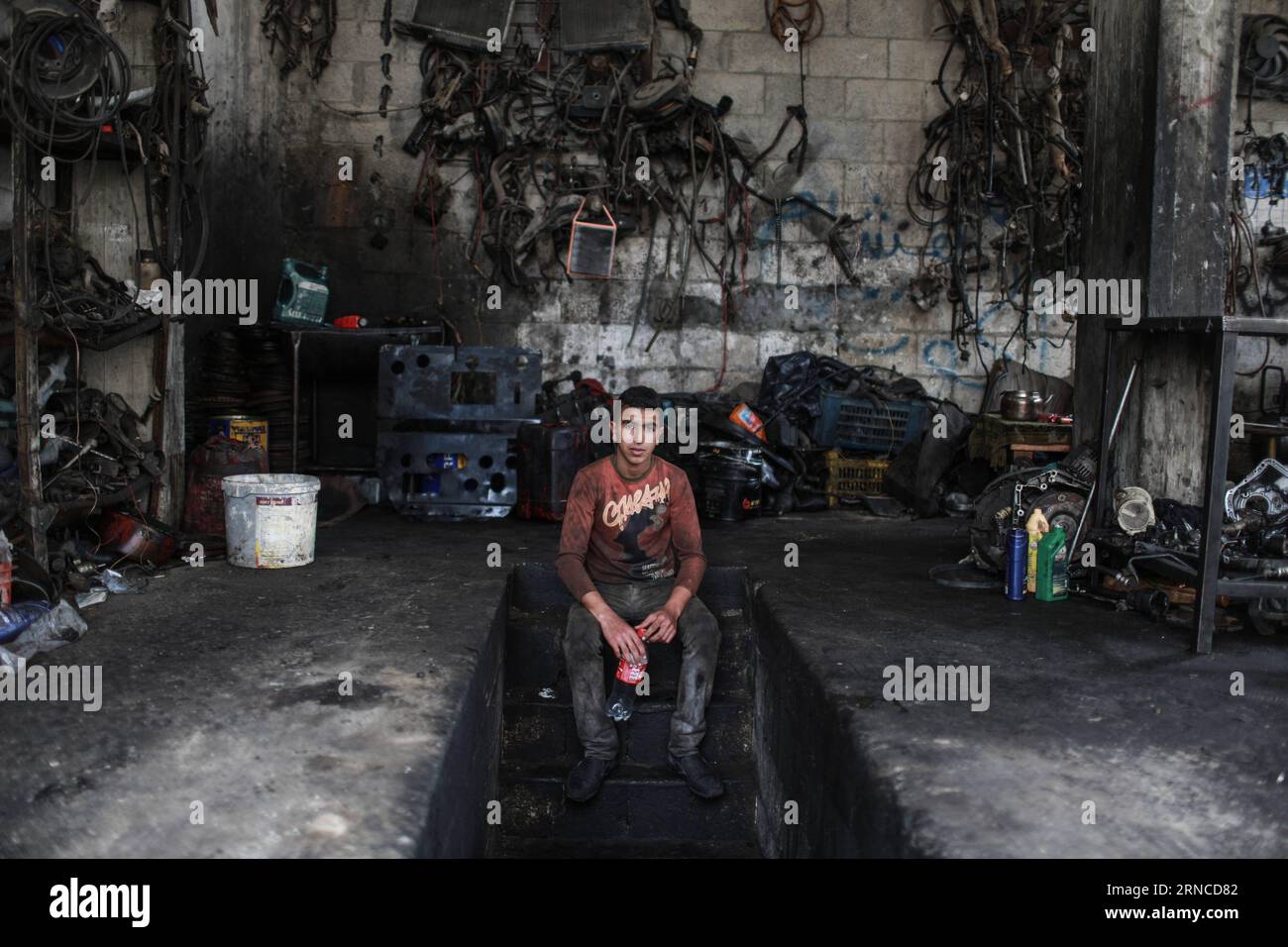 (160405) -- GAZA, April 5, 2016 -- Palestinian boy Debes Talateni, 13, who works as mechanic to help his father support their family, sits at a garage in Gaza City on April 5, 2016. Many Palestinian young boys are trying to make a living and support their family. ) MIDEAST-GAZA-PALESTINIAN-CHILD WissamxNassar PUBLICATIONxNOTxINxCHN   Gaza April 5 2016 PALESTINIAN Boy Debes  13 Who Works As Mechanic to Help His Father Support their Family sits AT a Garage in Gaza City ON April 5 2016 MANY PALESTINIAN Young Boys are trying to Make a Living and Support their Family Mideast Gaza PALESTINIAN Child Stock Photo