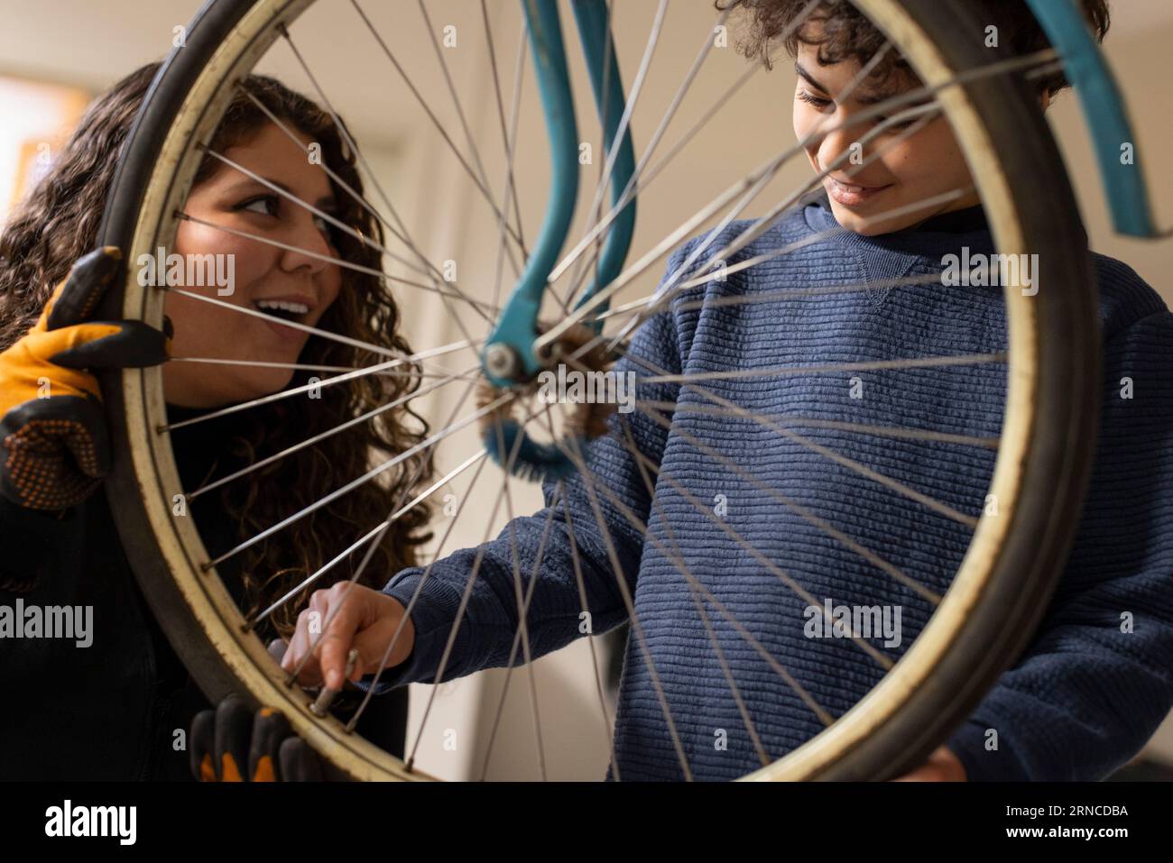 Smiling boy learning to fix valve by female technician at recycling center Stock Photo