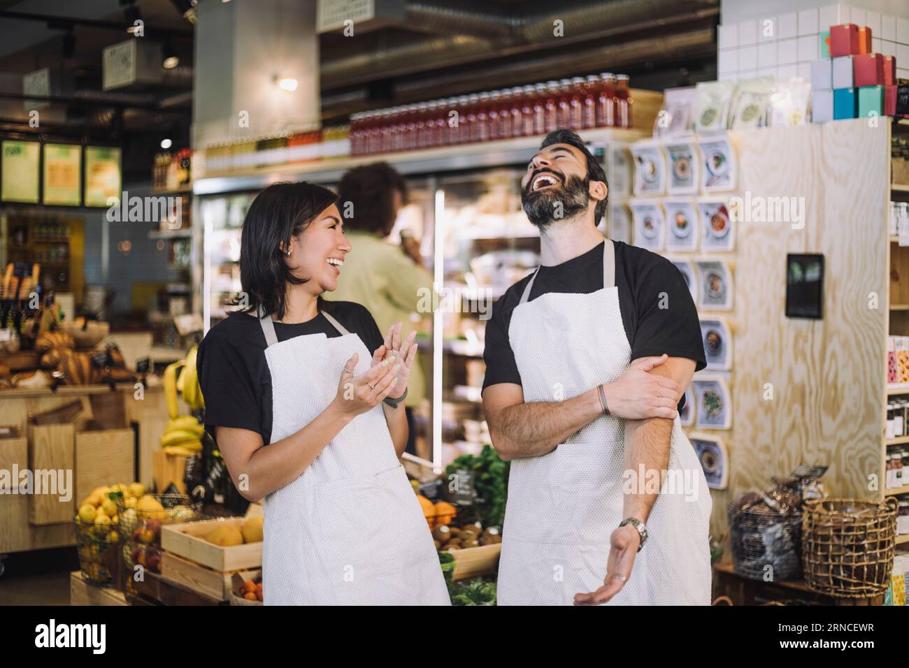 Cheerful multiracial male and female retail clerks wearing aprons