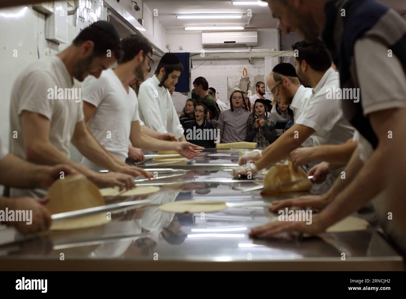 Jewish boys watch the baking of the Matzoth (unleavened bread) during the preparations for the upcoming Jewish Pesach (Passover) holiday on April 13, 2016 in Bnei Brak, near the city of Tel Aviv. Pesach, which will be marked on April 22, 2016, commemorates the Israelites exodus from slavery in Egypt some 3,500 years ago and their plight by refraining from eating leavened food products. ) (lyi) MIDEAST-JERUSALEM-PASSOVER-FOOD GilxCohenxMagen PUBLICATIONxNOTxINxCHN   Jewish Boys Watch The Baking of The matzoth unleavened BREAD during The preparations for The upcoming Jewish Pesach Passover Holid Stock Photo