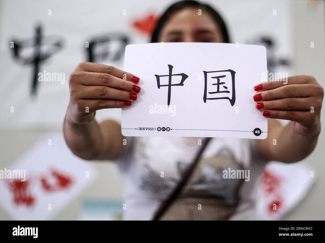 SAO PAULO (BRAZIL), April 18, 2016 -- Image taken on April 18, 2016 shows a student holding a card with Chinese characters meaning China during a Chinese language class at CEU Meninos municipal public school in Sao Paulo, Brasil. Chinese classes at CEU Meninos school are promoted in partnership between the school and the Confucius Intitute. Currently 125 students from six to fourteen years old attend the classes in CEU Meninos . The Day of Chinese Language is celebrated annually on April 20, aiming to promote multilingualism, cultural diversity and equal usage of the official languages of the Stock Photo