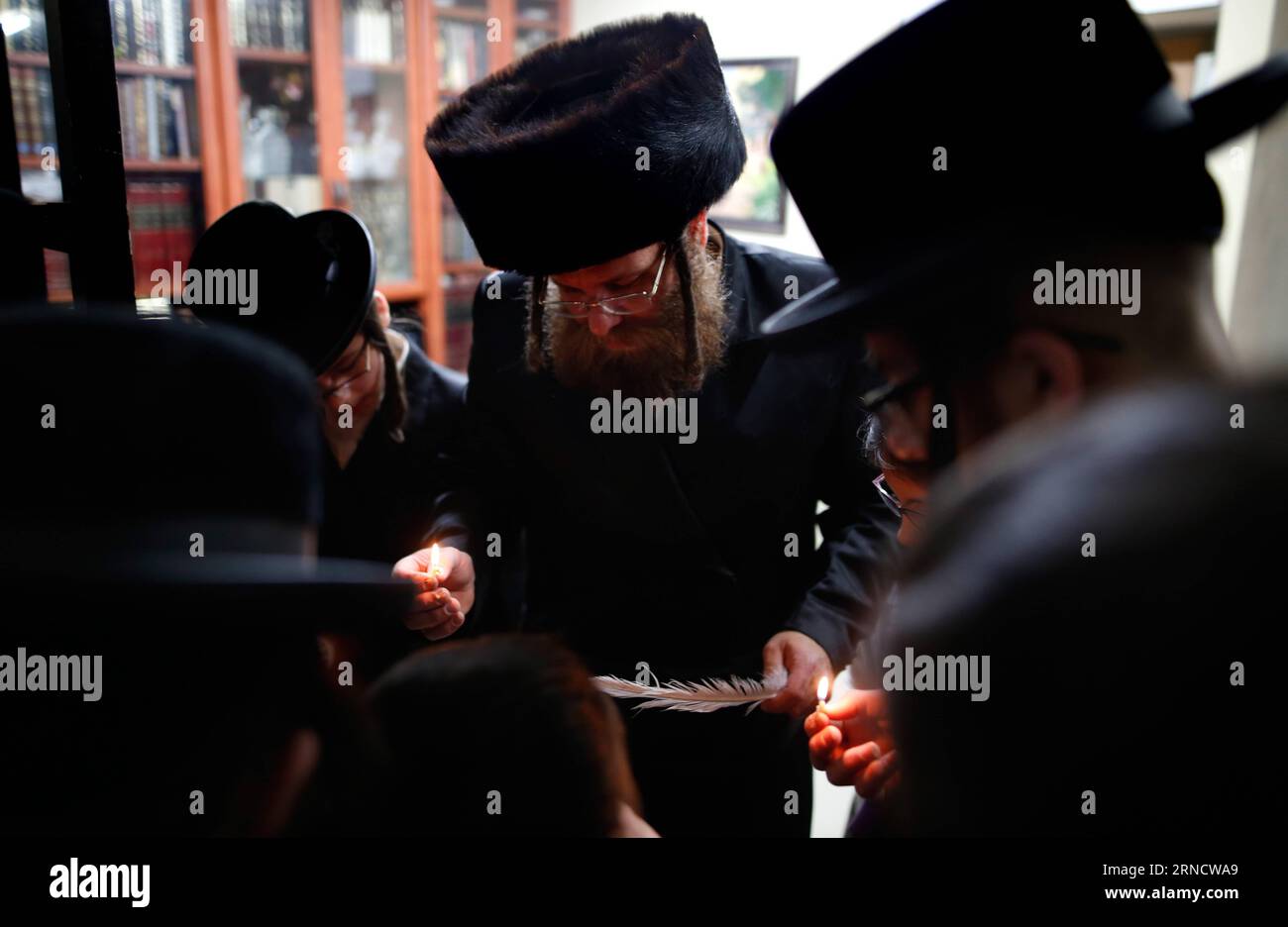 Vorbereitungen für Passah-Fest in Jerusalem, Israel (160422) -- TEL AVIV, April 22, 2016 -- An Ultra-orthodox Jewish family pray as they use a candle to search for the remains of bread in preparation for the upcoming Jewish holiday of Passover in Rehovot, south of Tel Aviv, Israel on April 21, 2016. Passover, which will be marked on April 22, 2016, commemorates the story of the Exodus as described in the Hebrew Bible especially in the Book of Exodus, in which the Israelites were freed from slavery in Egypt. ) ISRAEL-TEL AVIV-PASSOVER GilxCohenxMagen PUBLICATIONxNOTxINxCHN   Preparations for Pa Stock Photo
