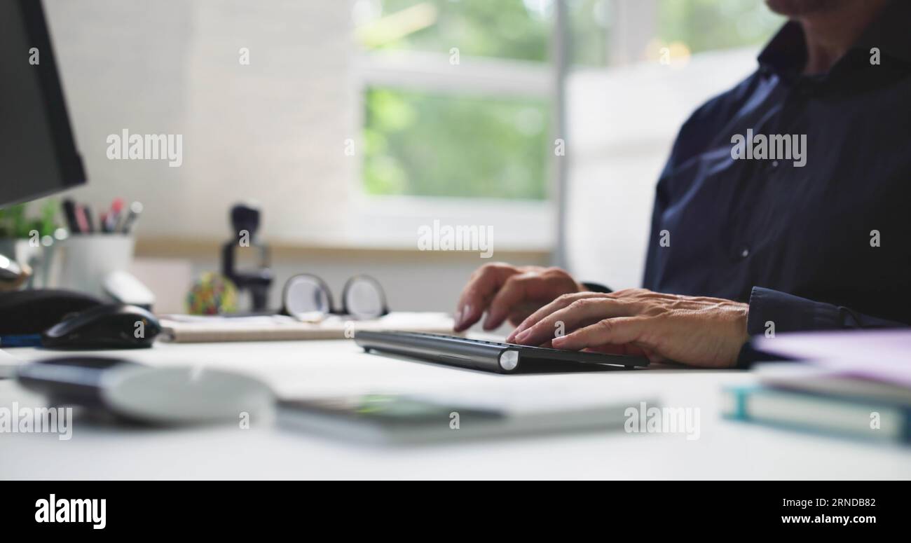 Man Working In Office On Desktop PC Stock Photo