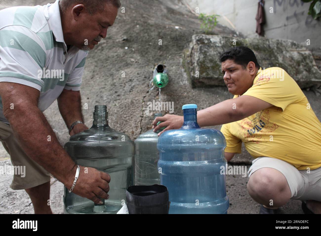 People fill jugs with water in Caracas, capital of Venezuela, May 17, 2016. According to local press, the Guri dam, the most important generator of hydroelectricity in Venezuela, has been affected by a severe drought, which prompts Venezuelan Government to implement some measures to save water and electricity. Boris Vergara) (cyc) VENEZUELA-CARACAS-ENVIRONMENT-DROUGHT e BorisxVergara PUBLICATIONxNOTxINxCHN   Celebrities FILL jugs With Water in Caracas Capital of Venezuela May 17 2016 According to Local Press The Guri Dam The Most IMPORTANT Generator of hydroelectricity in Venezuela has been Af Stock Photo