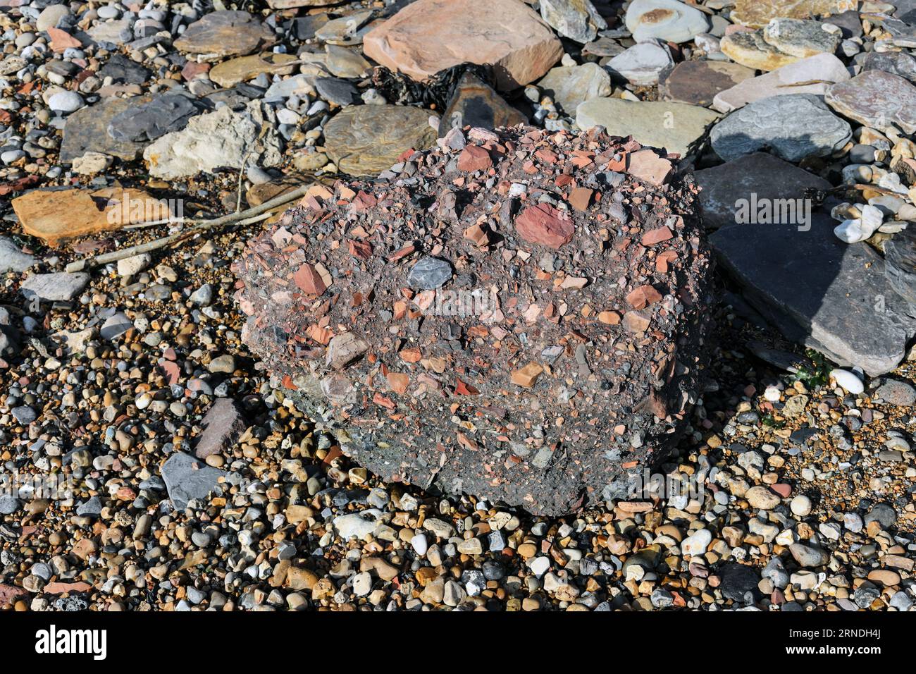 Industrial Waste from Blast Furnaces and Coal Mines that is slowly being eroded and washed away by the sea on the Blast Beach, Durham Heritage Coast, Stock Photo