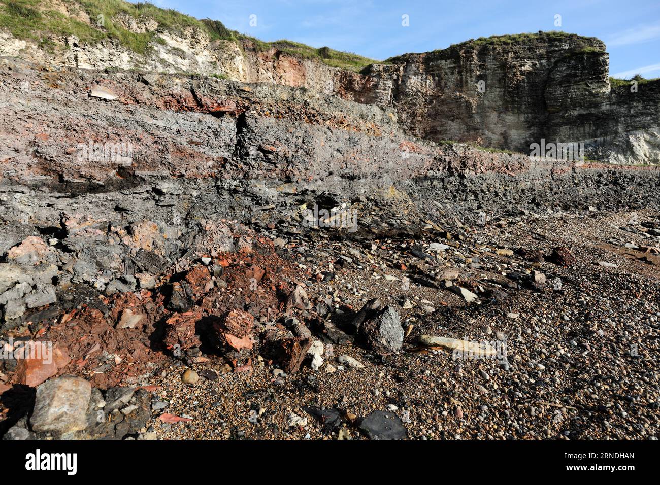 Layers of coal mine and blast furnace waste along with other industrial debris that is slowly being eroded and washed away by the sea on the Blast Bea Stock Photo