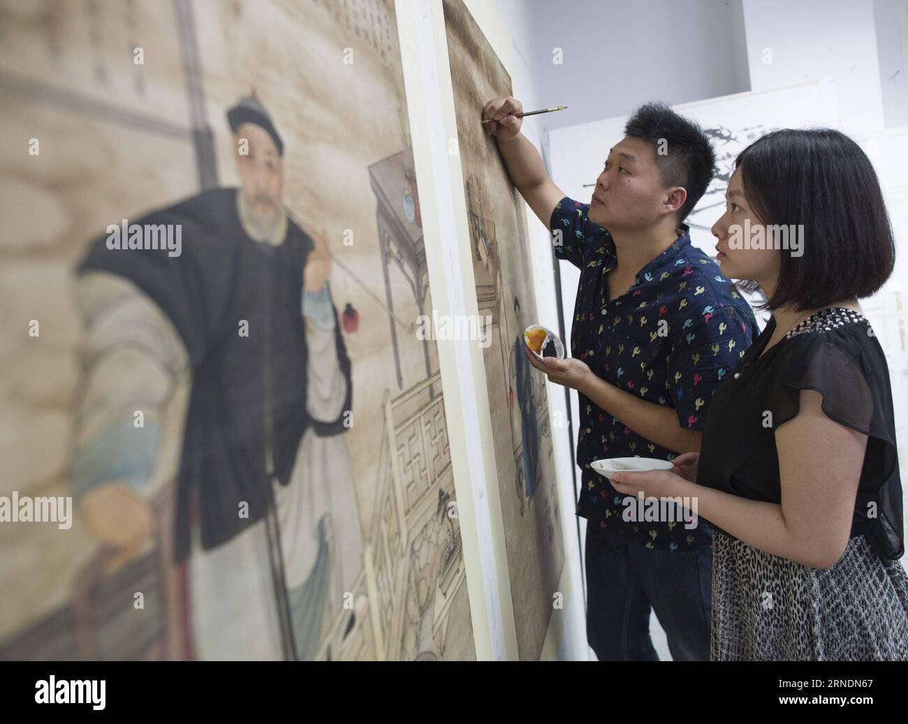 Zhao Xiaolong (L) and his wife Zhang Xiaolong repair a cultural relic ...