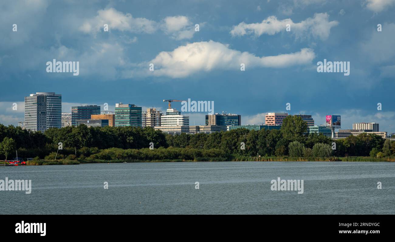 Amsterdam, The Netherlands, 26.08.2023, Skyline of Amsterdam zuidoost, modern high-rise office buildings seen from the Ouderkerkerplas lake Stock Photo