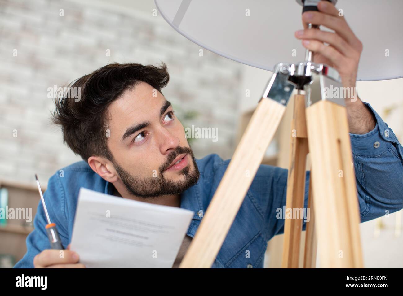 man changing light bulb in pendant lamp indoors Stock Photo