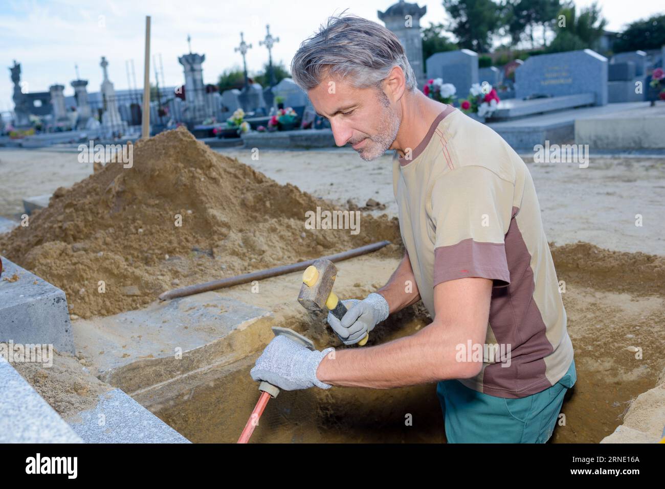 community cemetery worker digging a grave Stock Photo Alamy