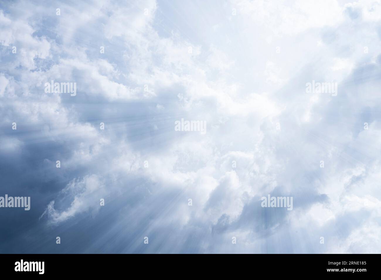 Sky background. The rays of the sun break through dense dramatic clouds. Stock Photo