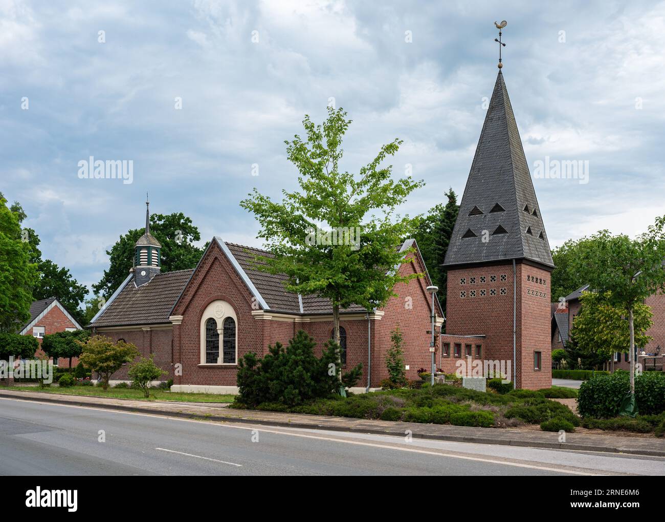 Lullingen, Geldern, North Rhine-Westphalia, Germany, July 14, 2023 - Local catholic church and asphalt road of the village Stock Photo