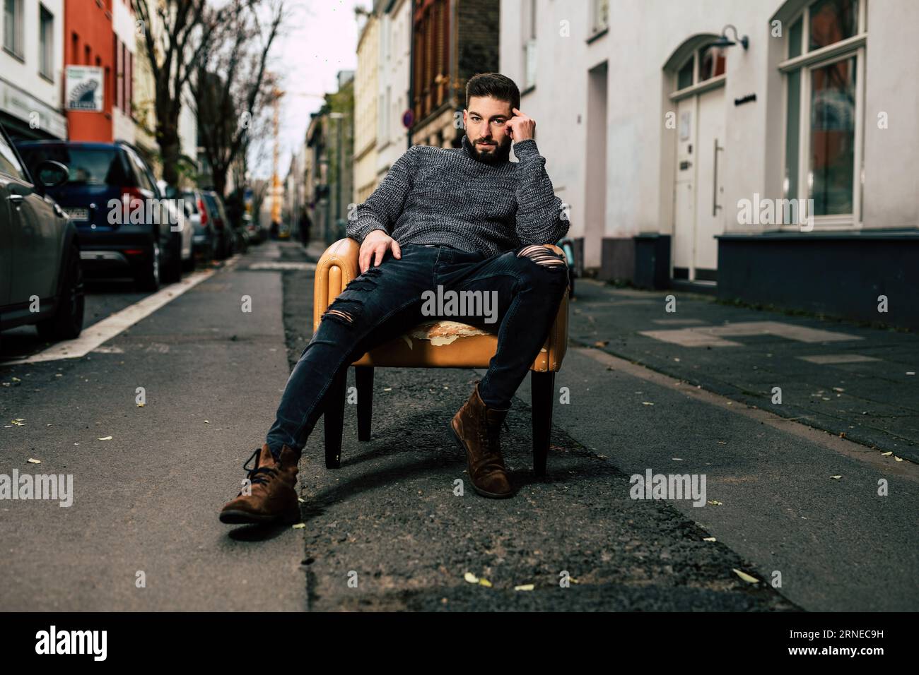 man lean and chill on chair on street in urban city while look bored at ...