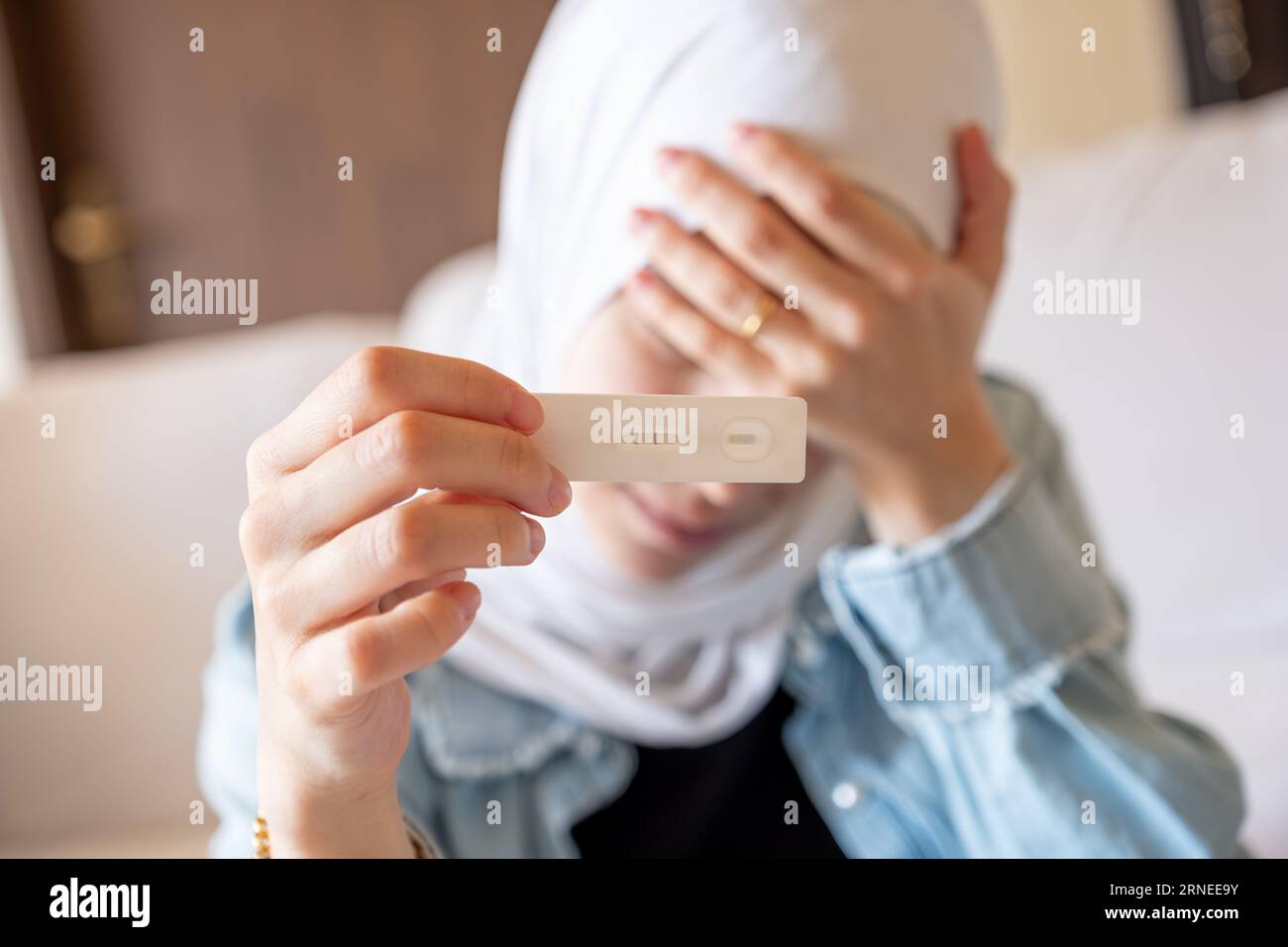 Female hand holding pregnancy tests with receipts and calculator in the