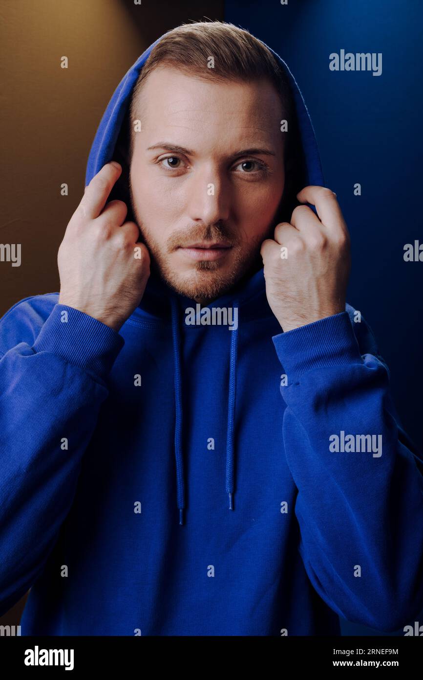 man with hoodie pull hood over his head look mysterious and