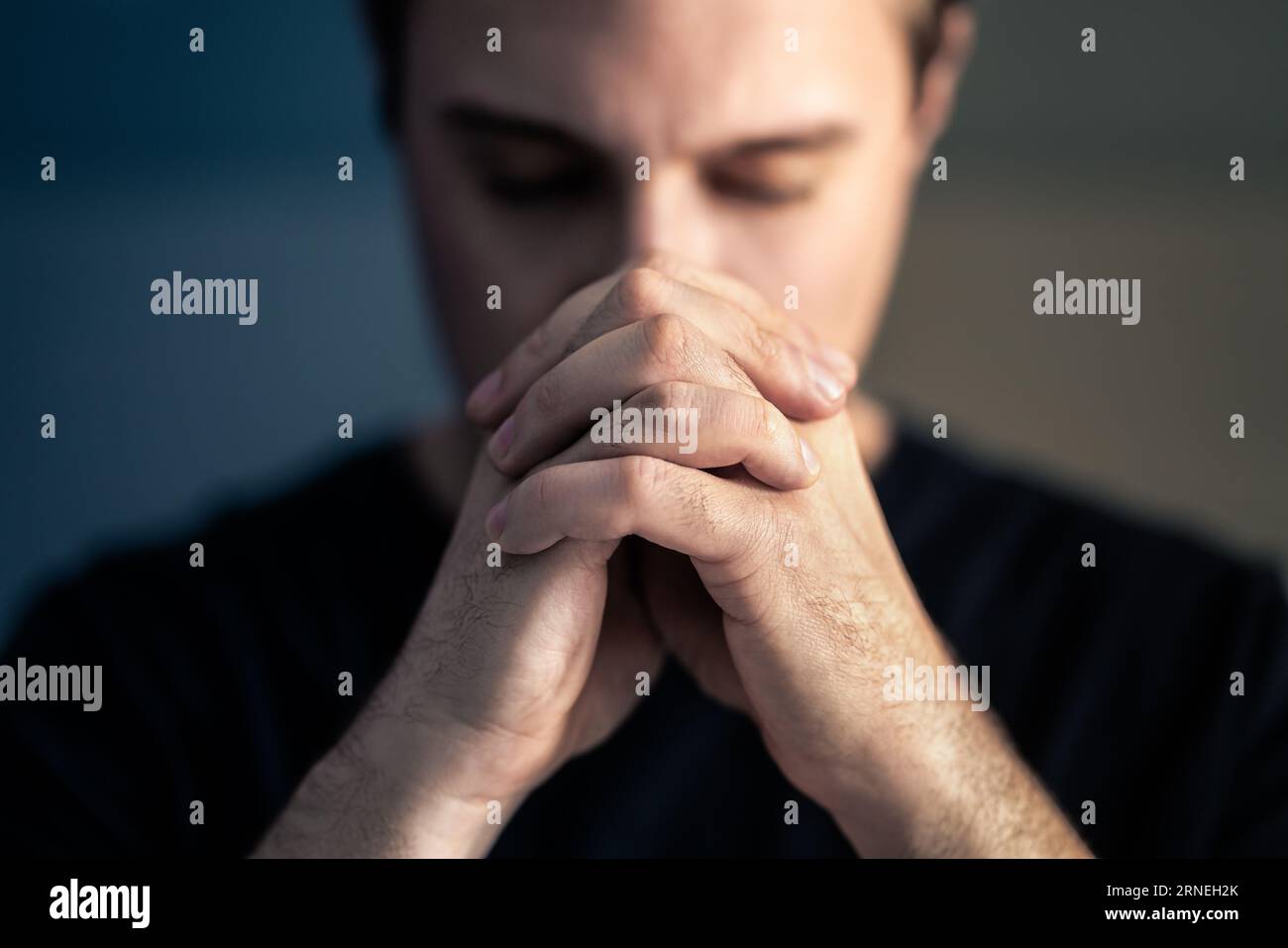 Praying hands. Prayer to God. Catholic or Christian man. Faith, religion and belief. Help and hope from Bible and church. Worship Jesus. Stock Photo