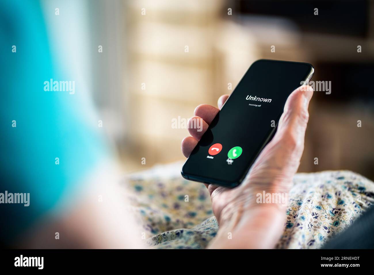 Old woman and phone call with hidden mobile number. Senior mature lady and fraud and scam caller. Love and romance hoax. Holding smartphone in hand. Stock Photo