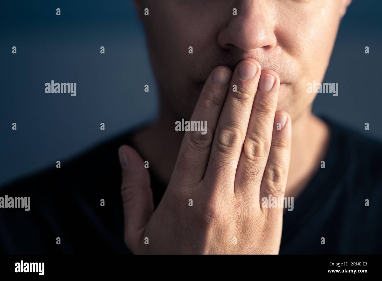Oops, secret gossip. Lips sealed, mute. Surprise, shock. Quiet shy man cover mouth with hand. Censorship, freedom of speech or taboo concept. Stock Photo