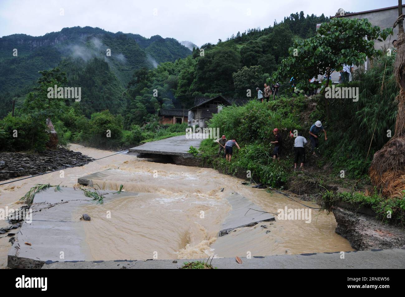 Villagers clear out a bypath beside a damaged road at Taiping Village in Tongren, southwest China s Guizhou Province, July 4, 2016. Continuous heavy rainfall has affected 140,000 residents in Tongren, and rain-triggered floods have also damaged crops, roads, telecommunication and electricity facilities. China s meteorological authority renewed its orange alert for heavy rain in the south and southwest of the country on Monday. ) (wyo) CHINA-GUIZHOU-HEAVY RAIN-FLOODS (CN) XiangxDingjie PUBLICATIONxNOTxINxCHN   Villagers Clear out a  Beside a damaged Road AT Taiping Village in Tongren Southwest Stock Photo