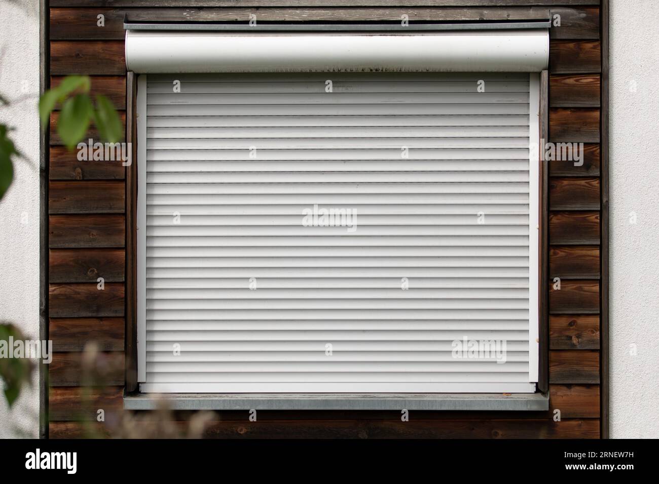 closed shutter on a house wall block out sun light from outside black out window and keeps the home cool and dark at hot summer day and night Stock Photo