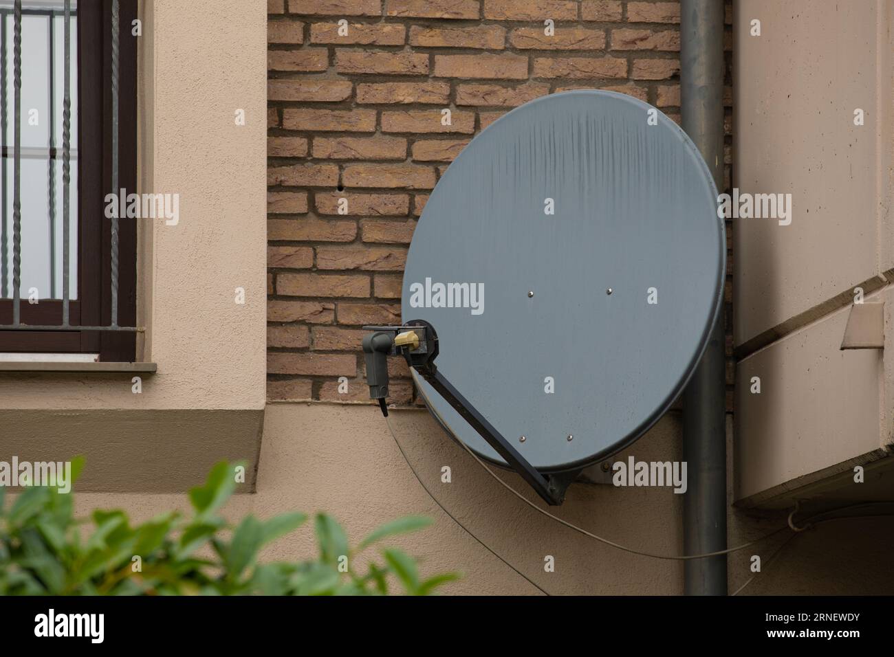 satellite dish antenna outdoor mounted at wall to recieve sat tv signal from outta space satellite Stock Photo