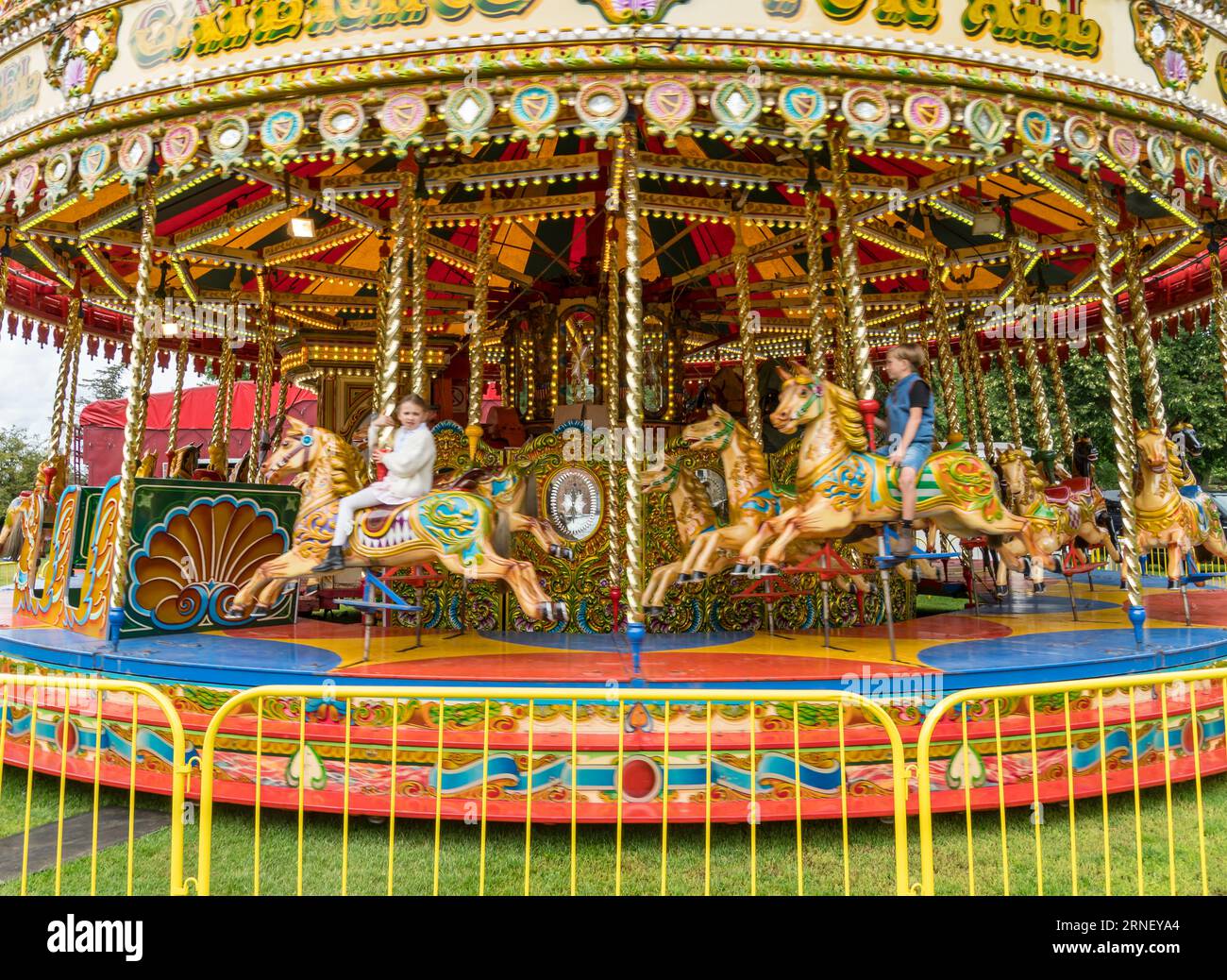 Children on galloper carousel moving at speed, The Lawn, Lincoln City, Lincolnshire, England, UK Stock Photo