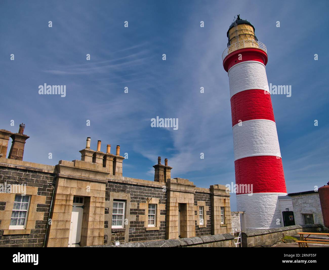 The lighthouse keeper houses and the red and white Eilean Glas Lighthouse on the east coast of the island of Scalpay in the Outer Hebrides, Scotland, Stock Photo