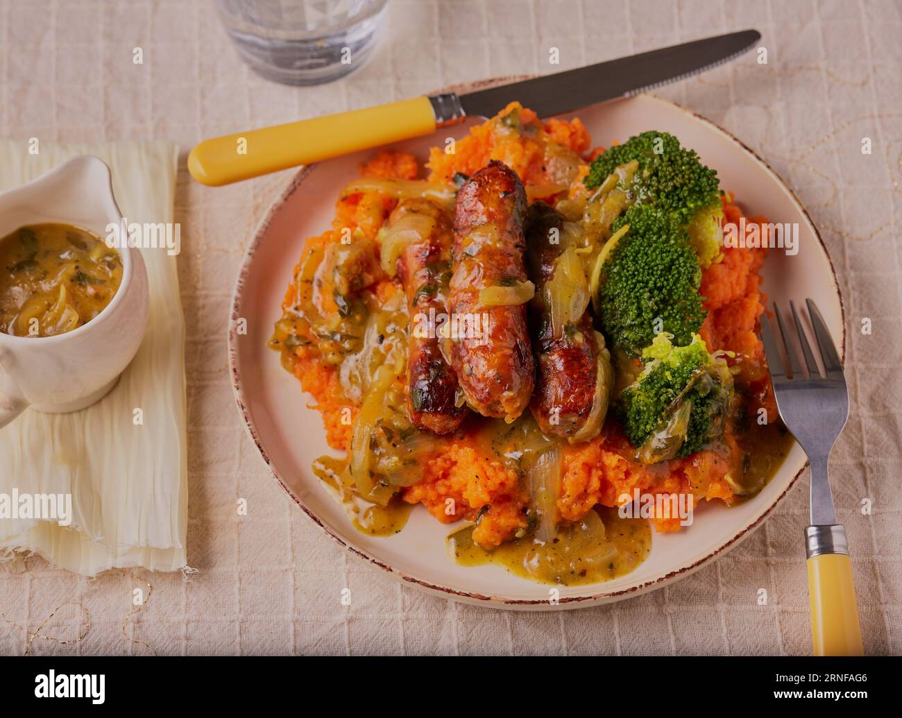 Cumberland sausages with mashed sweet potatoes and onion gravy. Stock Photo